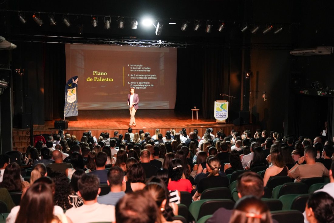 Sala cheia acompanhando a apresentação do plano de palestra